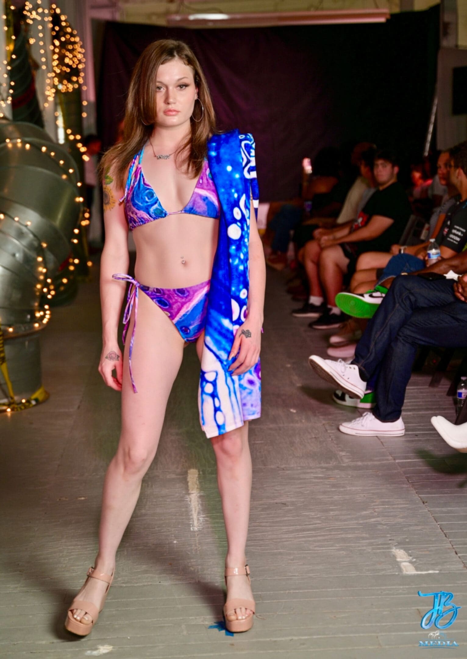 A woman in a bikini and towel on the runway.