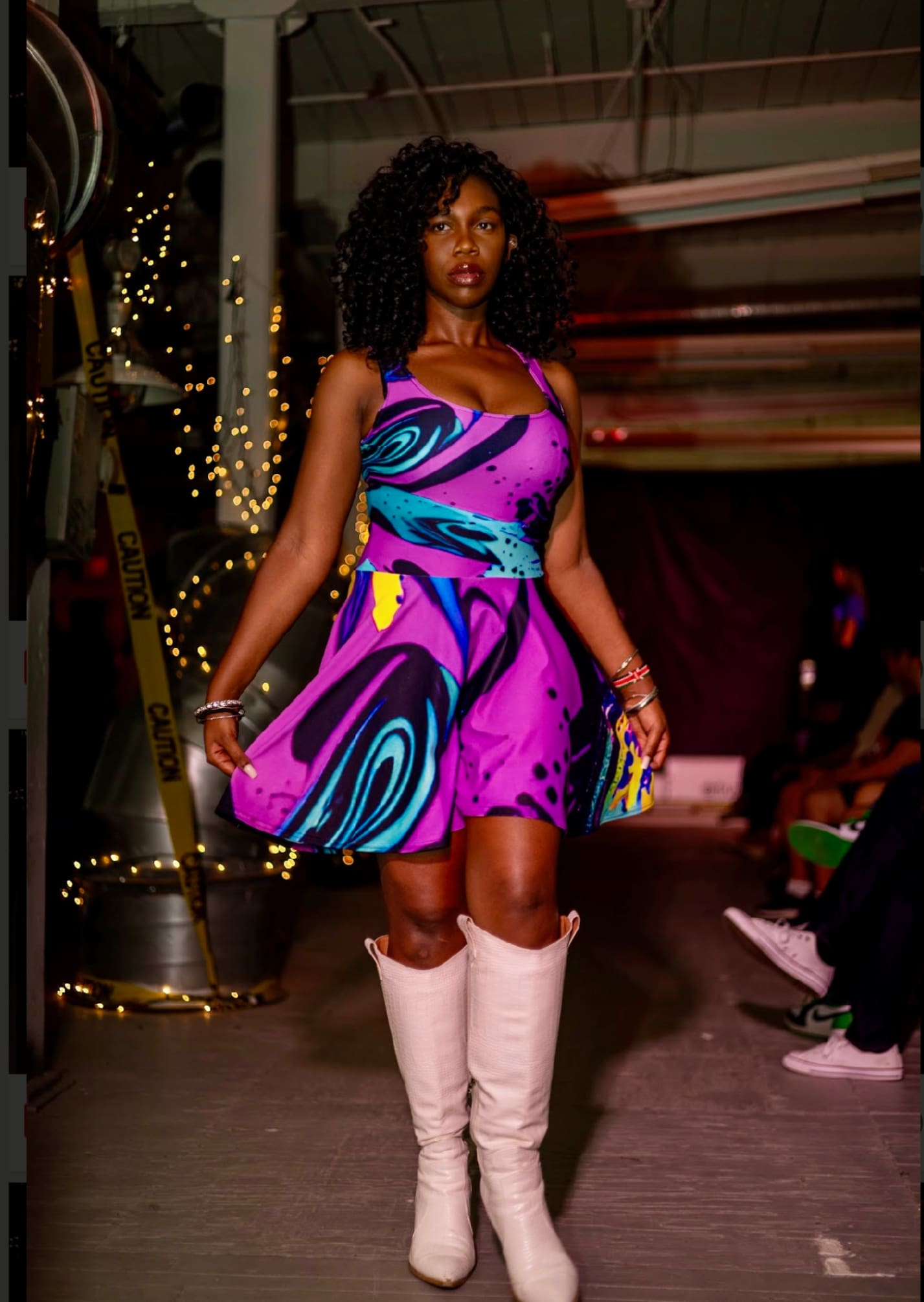 A woman in purple dress and white boots.