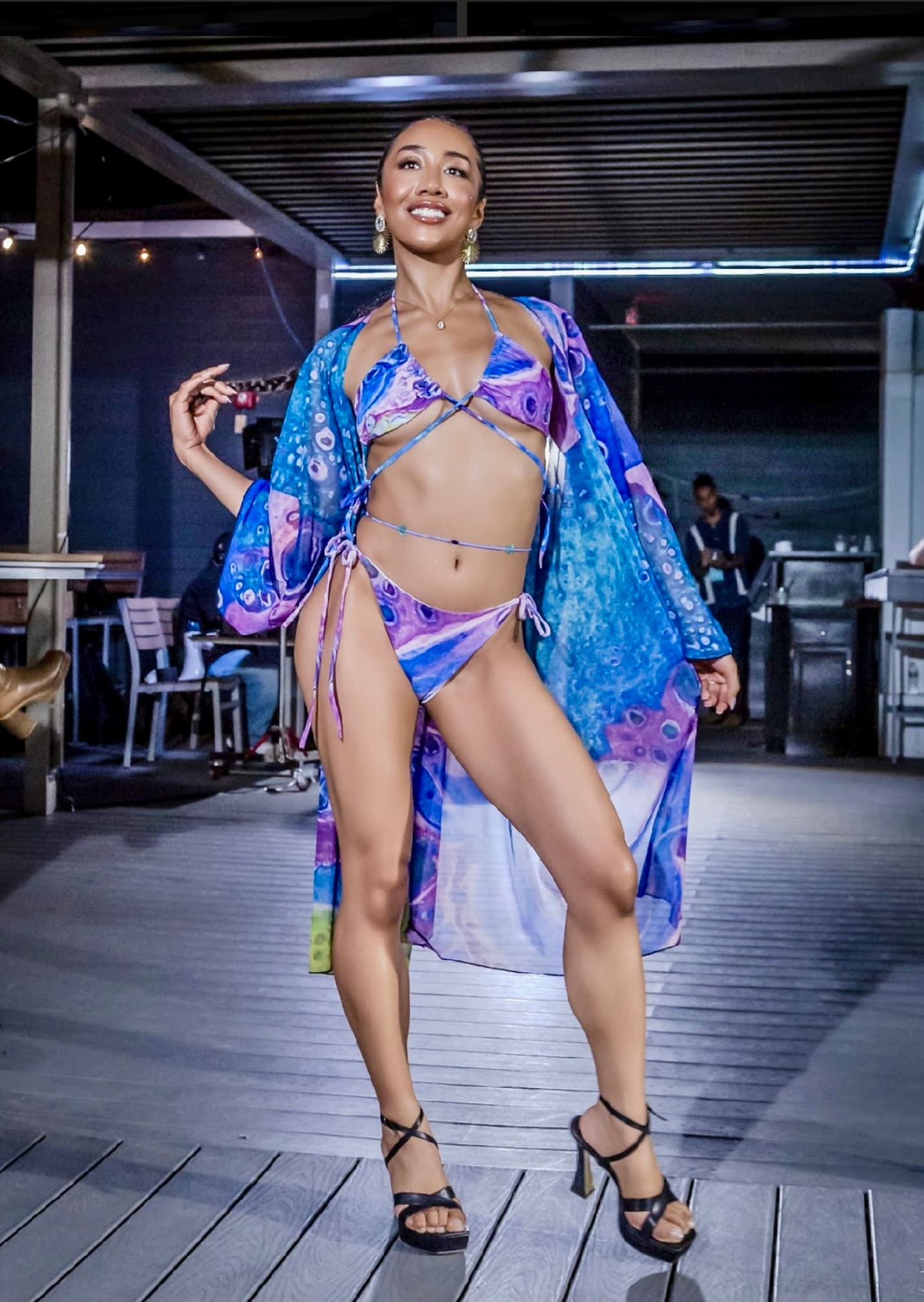 A woman in a bikini and robe on the runway.