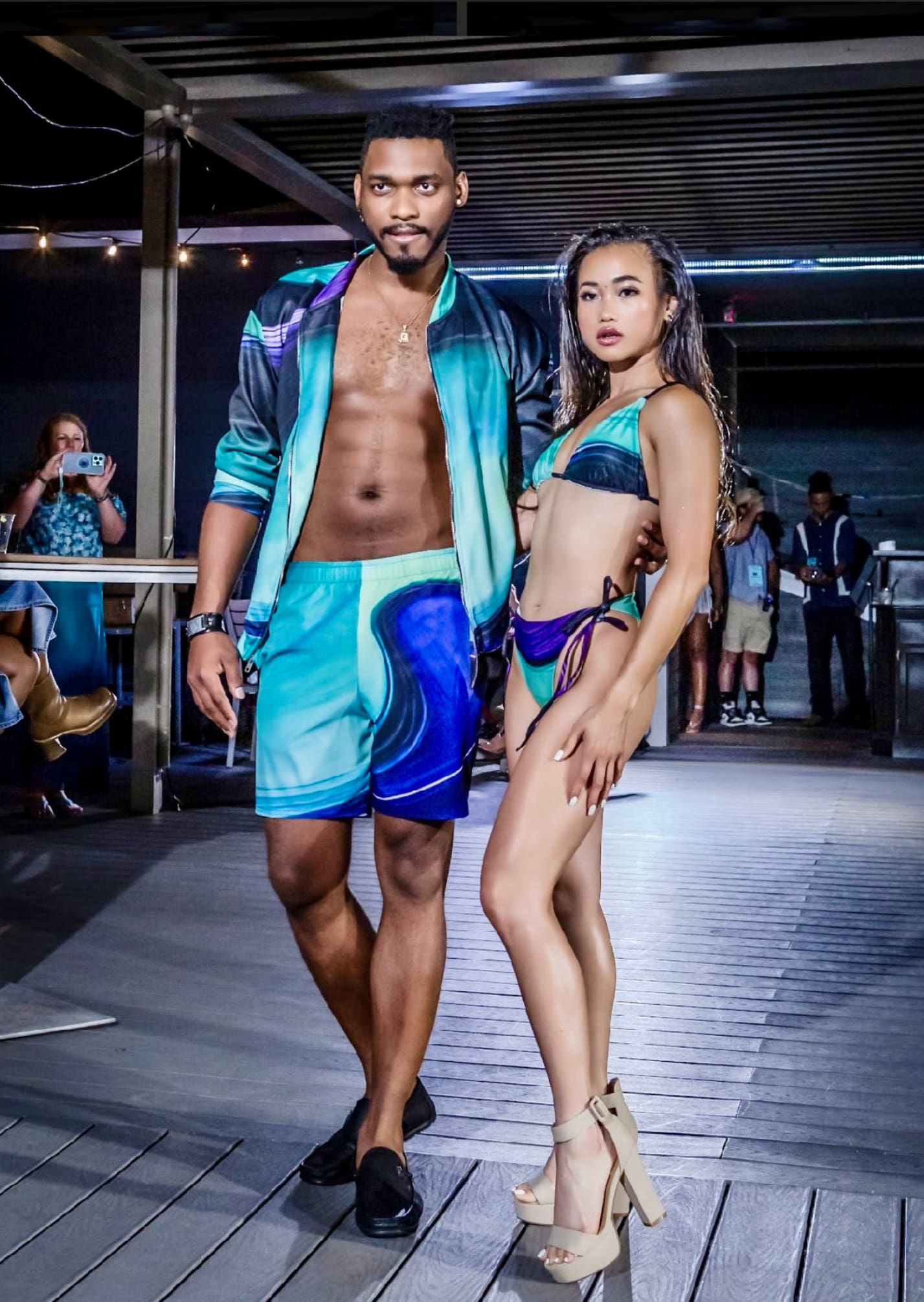 A man and woman in swim wear on the runway.