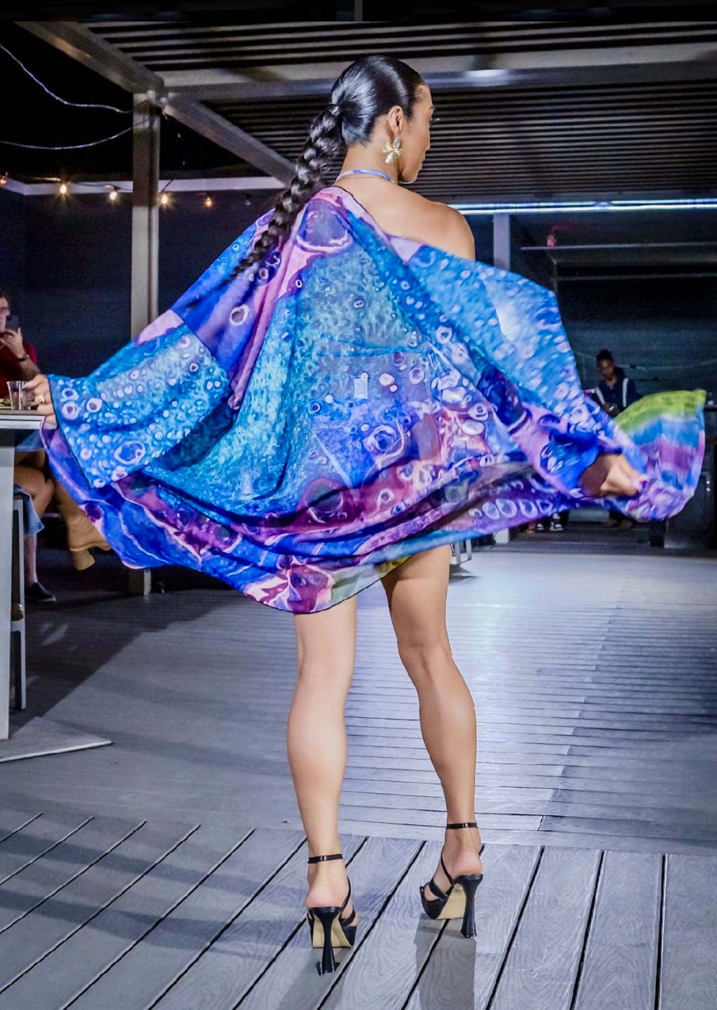 A woman in a colorful dress on the runway.