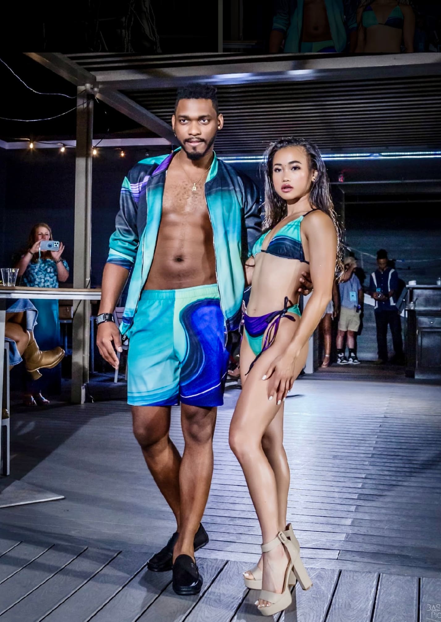 A man and woman in swim trunks on the runway.