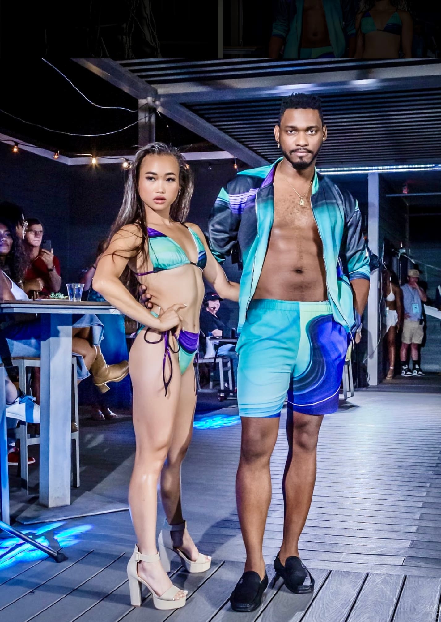 A man and woman in swim trunks on the runway.