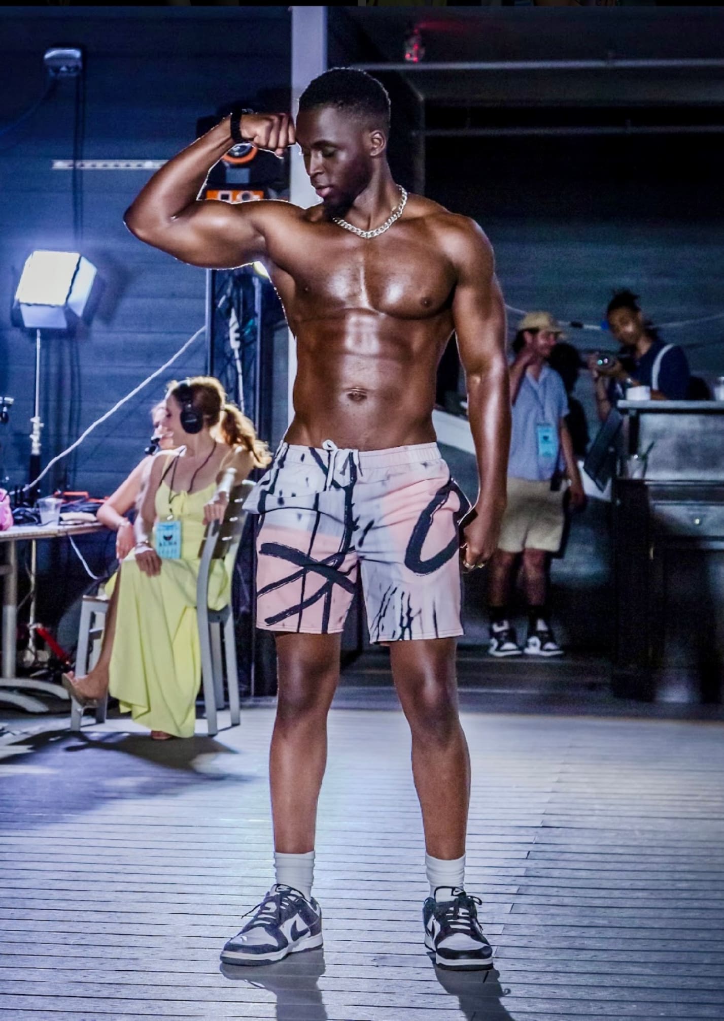 A man in shorts and no shirt standing on the runway.