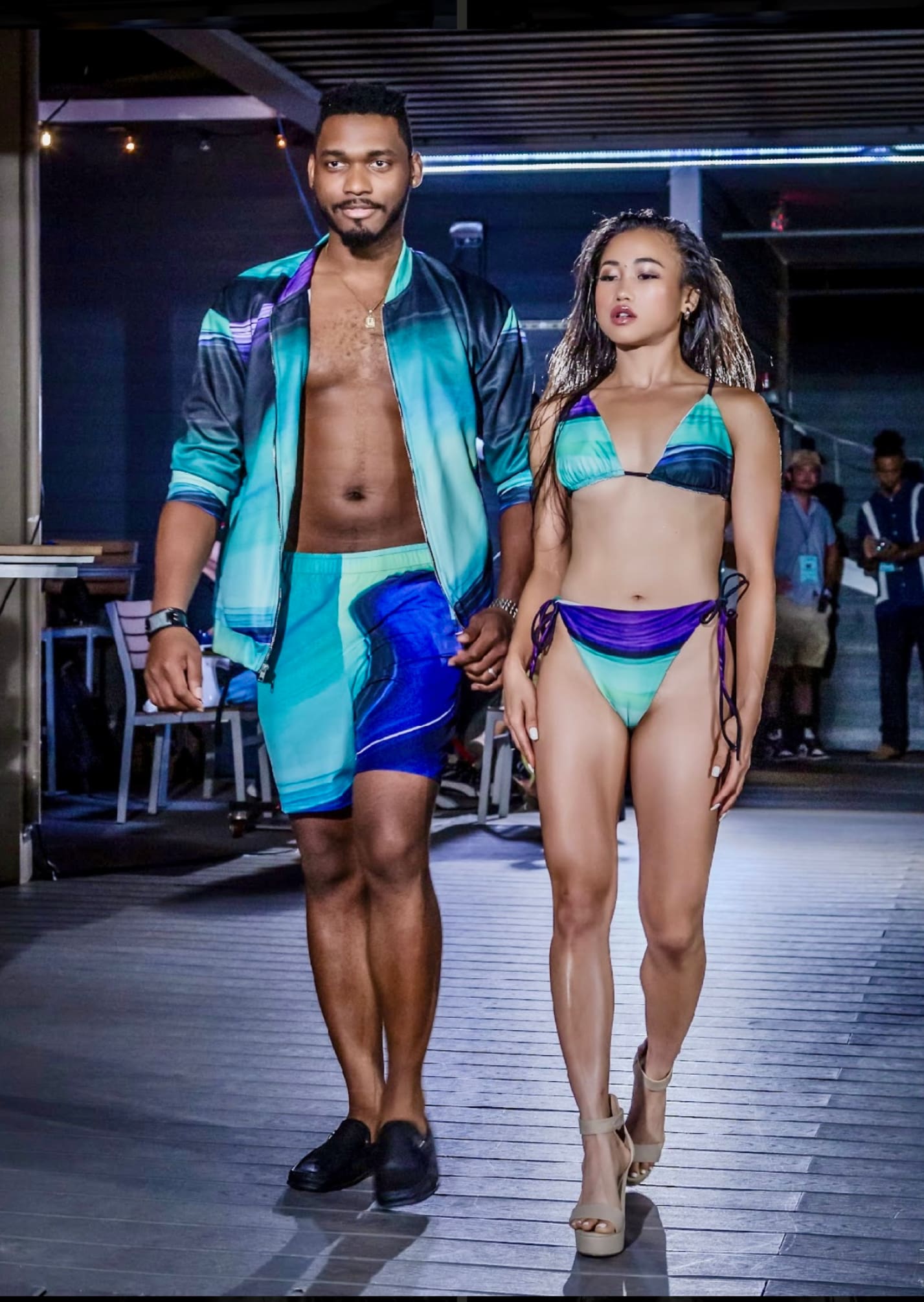 A man and woman walking down the runway.