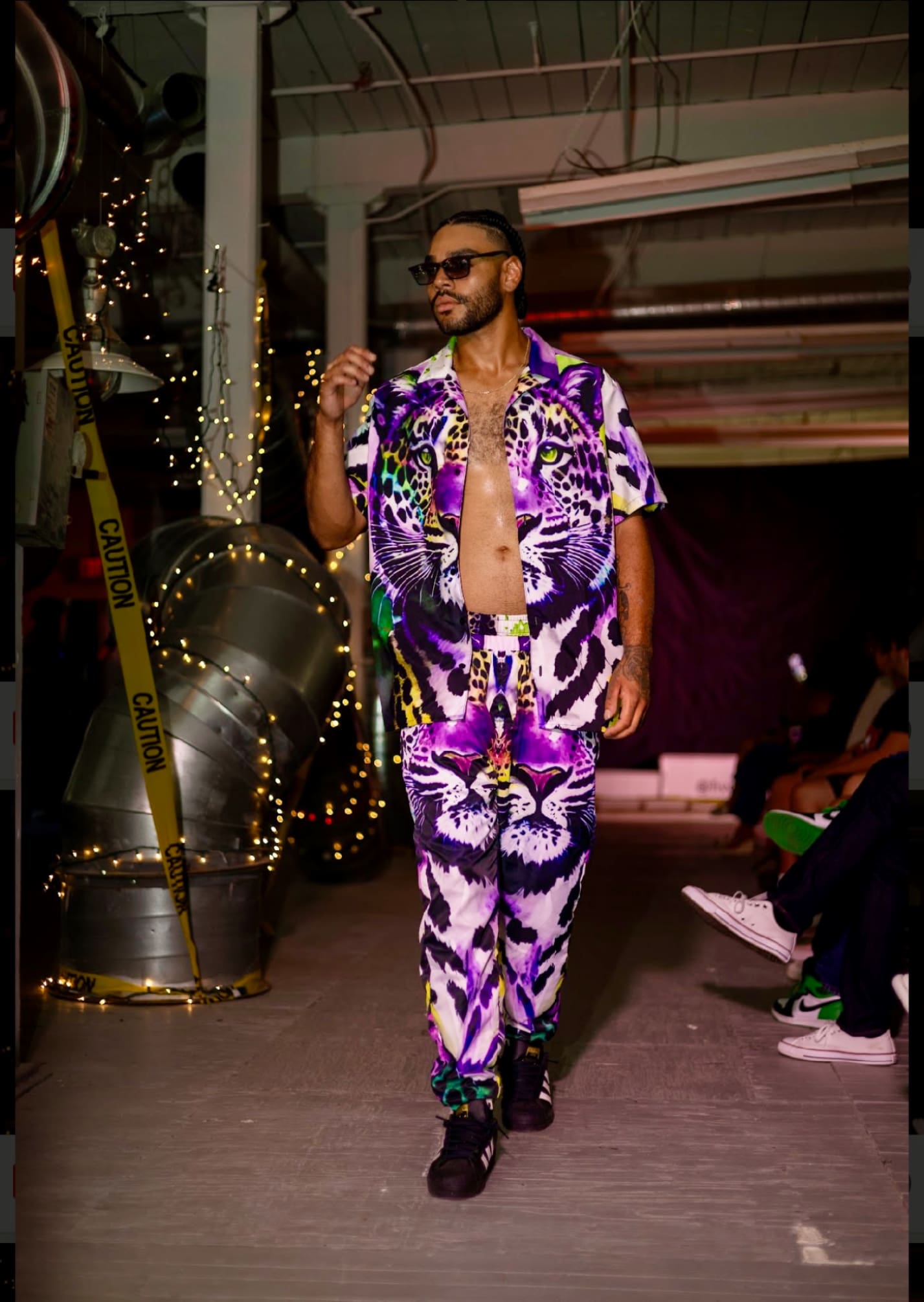 A man in purple and white shirt standing on the runway.