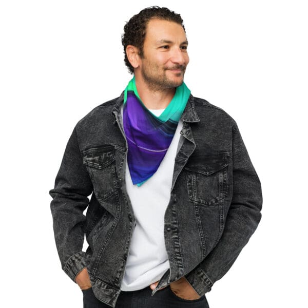 A man wearing a jean jacket and purple, blue and green scarf.