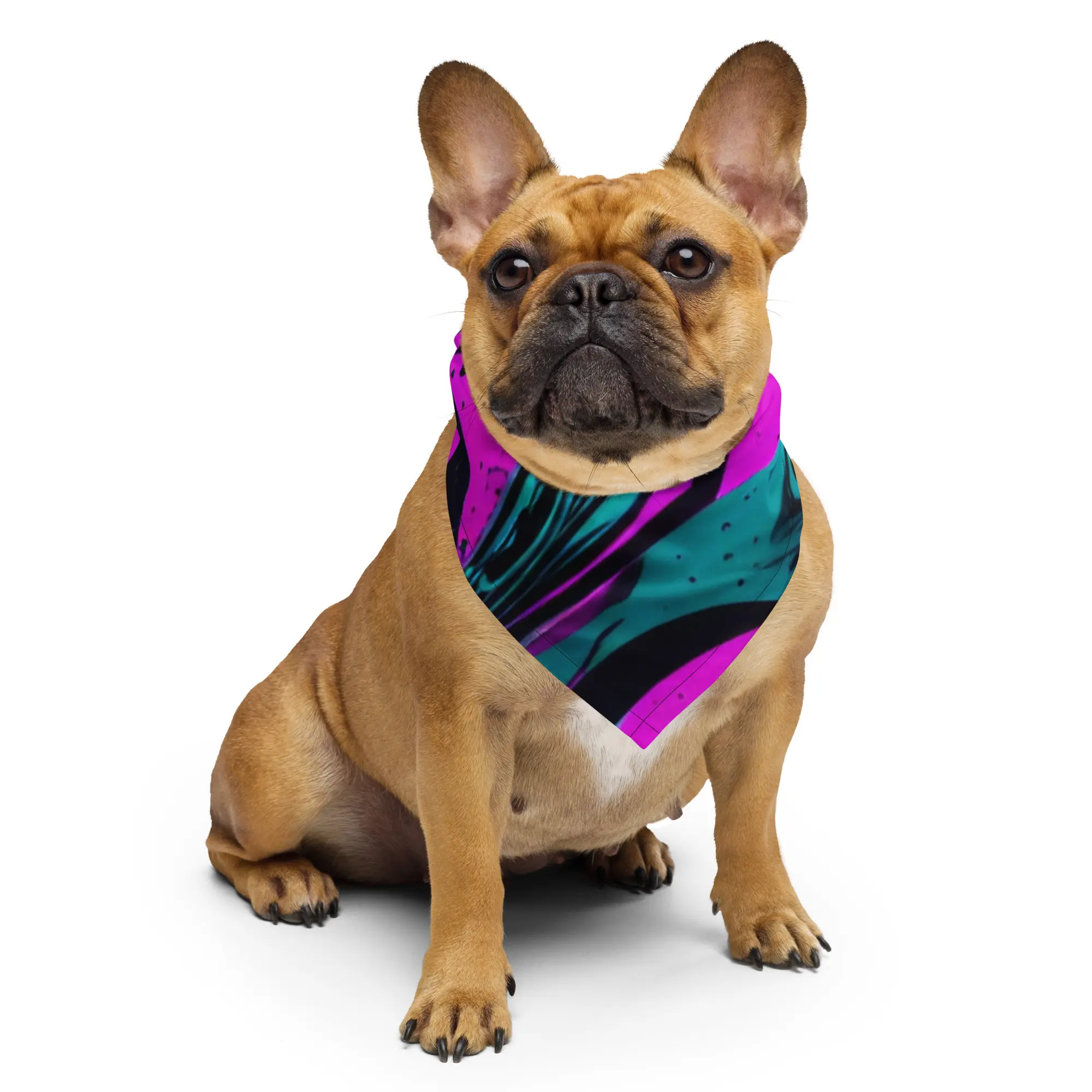 A brown dog sitting on the ground wearing a colorful bandanna.