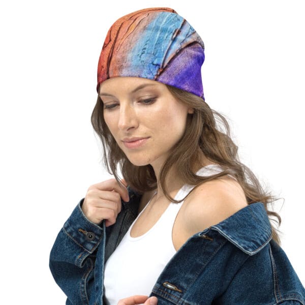 A woman wearing a denim jacket and a colorful hat.