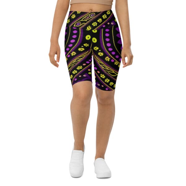 A woman wearing purple and green shorts with yellow dots.