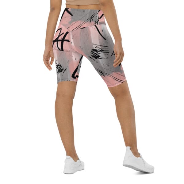 A woman wearing pink and gray shorts with graffiti.