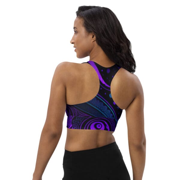 A woman wearing a sports bra with purple and blue designs.