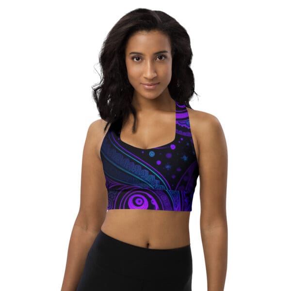 A woman wearing a sports bra with purple and blue designs.