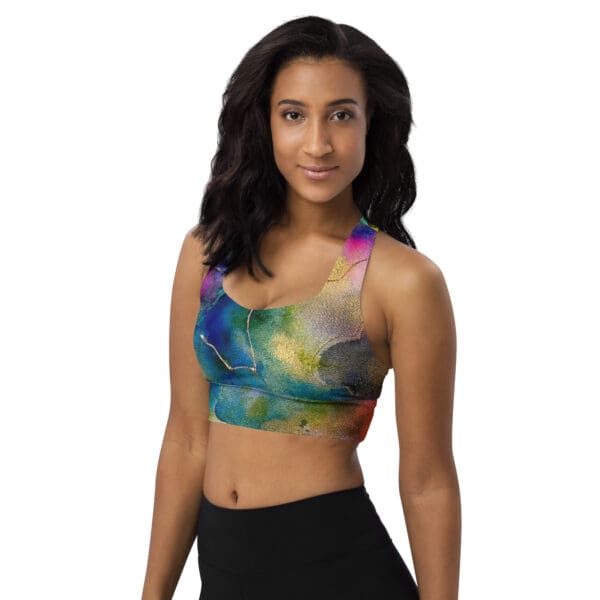 A woman wearing a sports bra with a colorful painting on it.