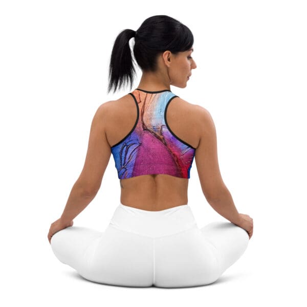 A woman sitting in the lotus position wearing a sports bra.