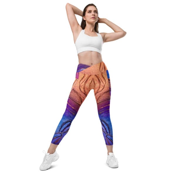 A woman is wearing colorful leggings and posing for the camera.