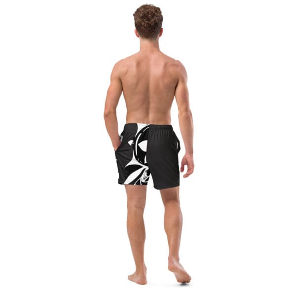 A man wearing black and white swim trunks.