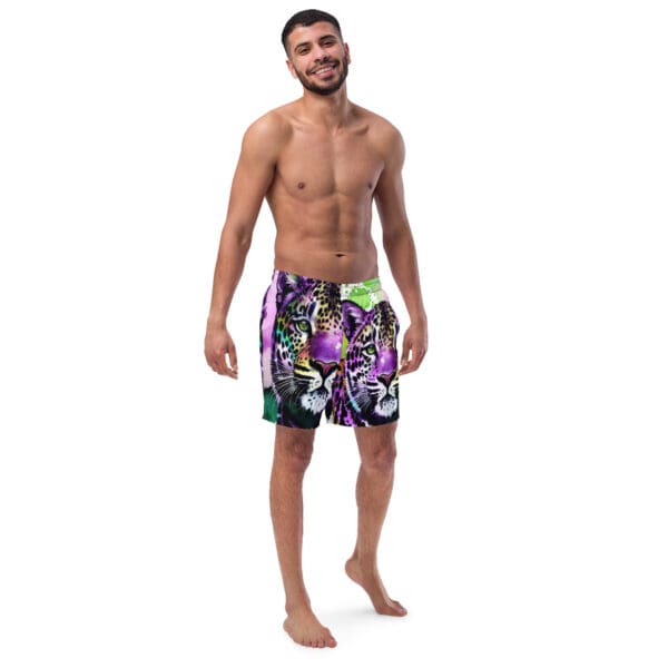 A man standing in front of the camera wearing swim trunks.