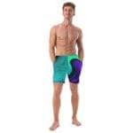 Man in colorful swim shorts posing confidently.
