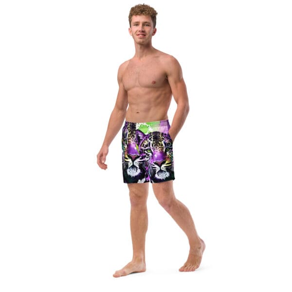 A man in swim trunks standing on the beach.