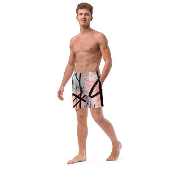 A man in swim trunks standing barefoot.