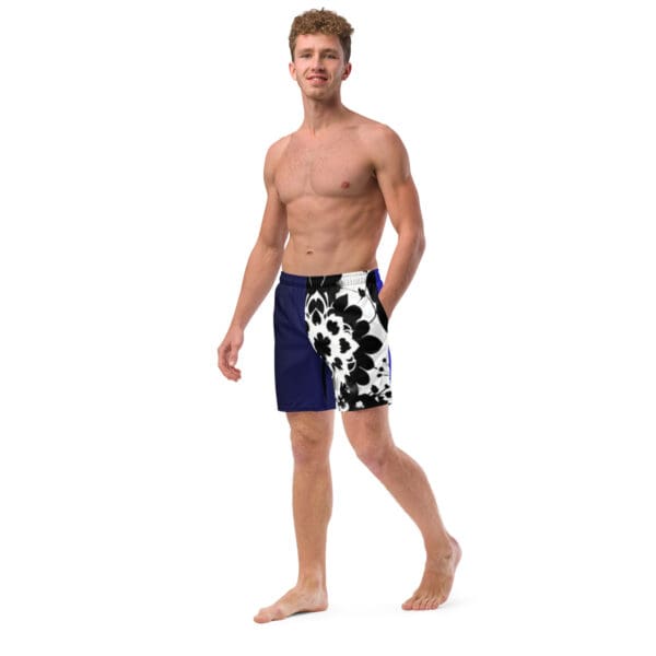 A man in swim trunks standing on the beach