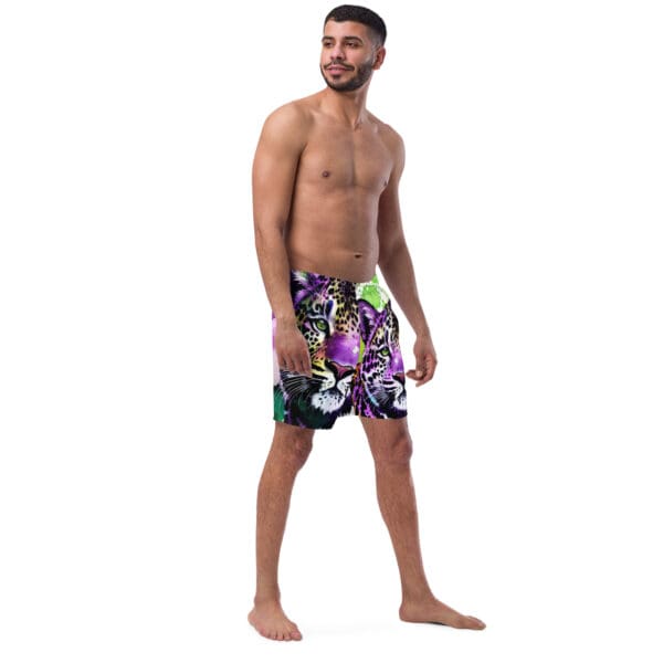 A man standing in front of the camera wearing swim trunks.