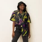 Young woman in colorful patterned shirt.