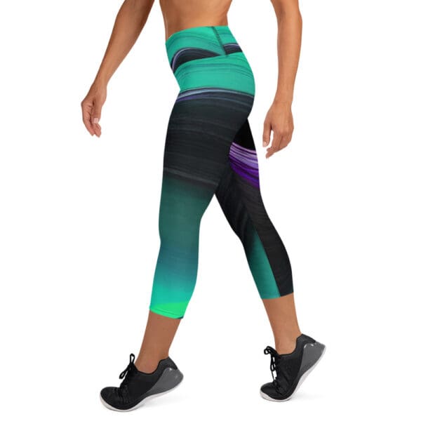 A woman is walking in the gym wearing a pair of green and black leggings.