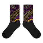 A pair of black socks with an image of a purple and yellow pattern.