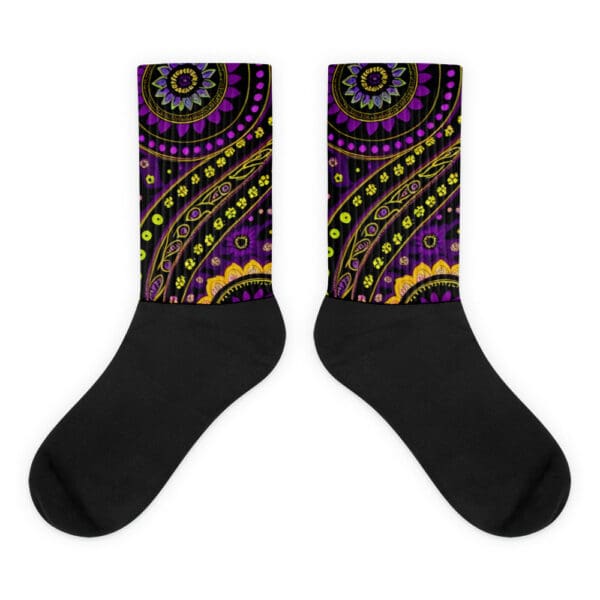 A pair of black socks with an image of a purple and yellow pattern.