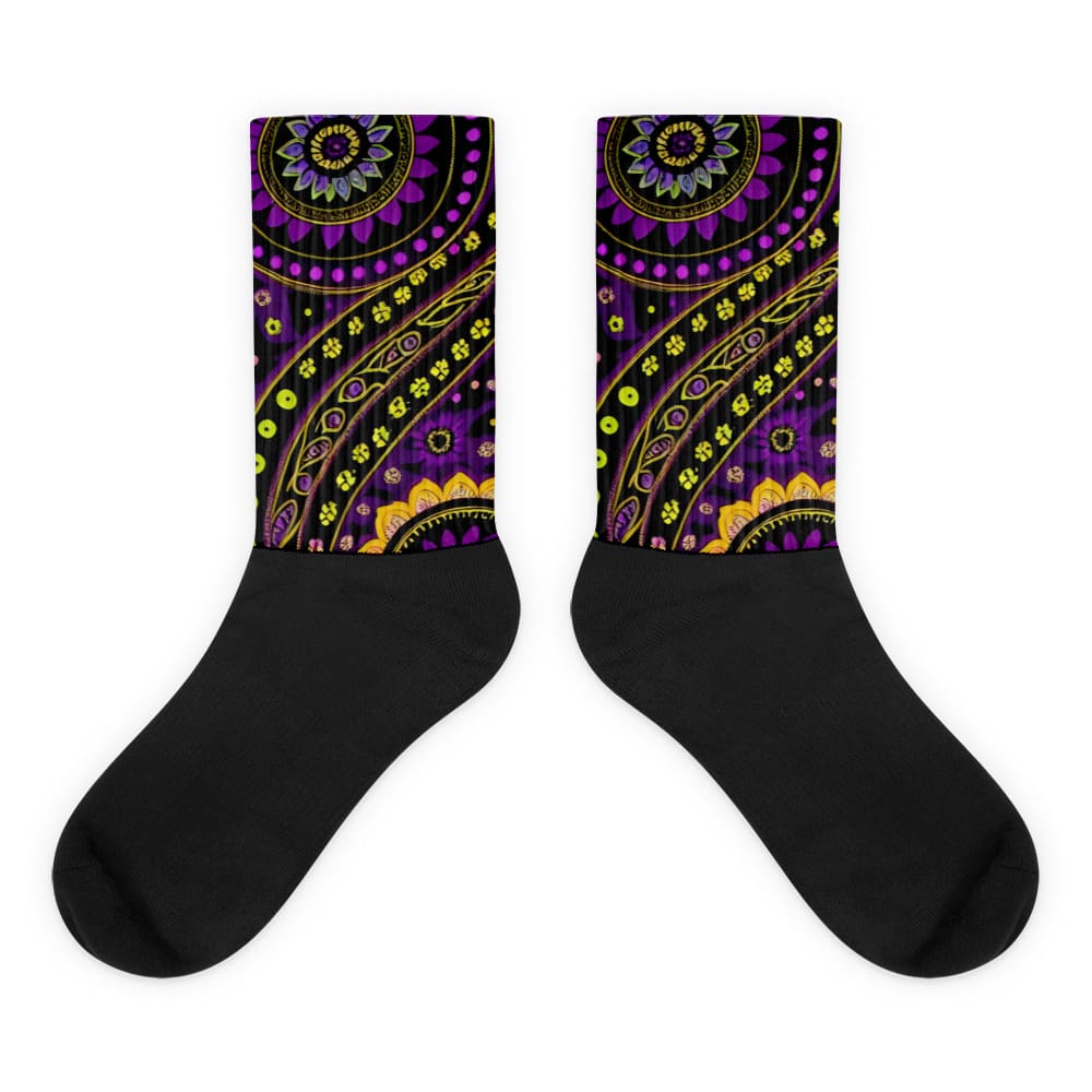 A pair of black socks with an image of a purple and yellow pattern.