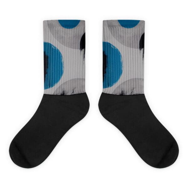 A pair of socks with blue and black polka dots.