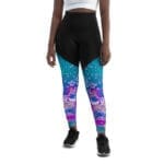 A woman wearing black and blue leggings with a pink unicorn design.