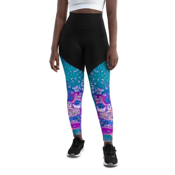 A woman wearing black and blue leggings with a pink unicorn design.