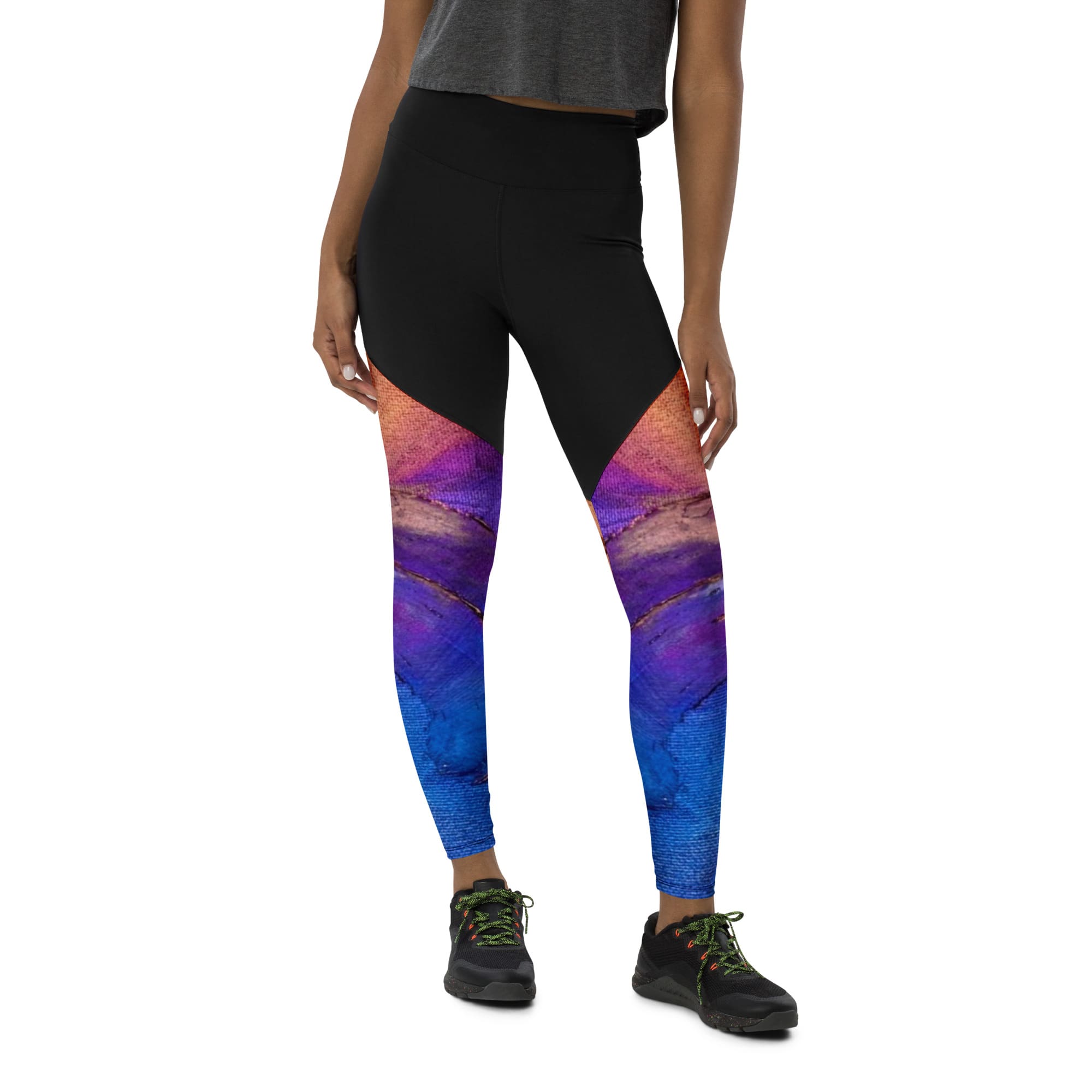 A woman wearing black and purple leggings with a colorful design.