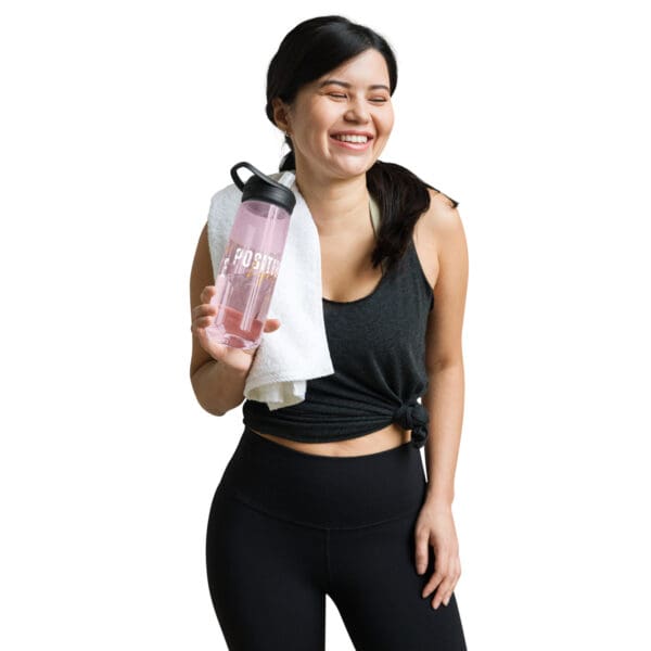 A woman holding onto a towel and water bottle