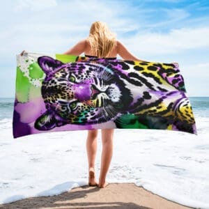 A woman standing on the beach with a towel.