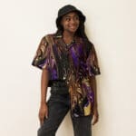 Young woman in colorful, abstract shirt.