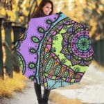 Woman holding a colorful mandala umbrella.