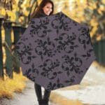Woman holding decorative umbrella on pathway.