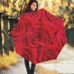 Woman with rose-patterned umbrella in park.