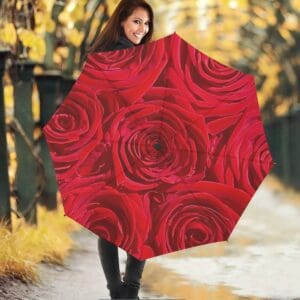 Woman with rose-patterned umbrella in park.
