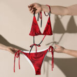 Red floral bikini held by two hands.