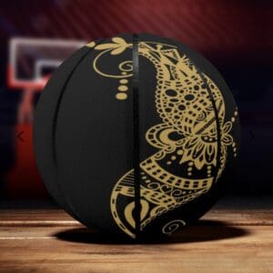 Black basketball with intricate gold designs.