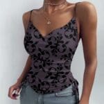 Woman in floral-patterned camisole and jeans.