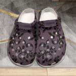Purple clogs with black floral pattern.