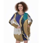 Woman in colorful abstract-patterned dress smiling.