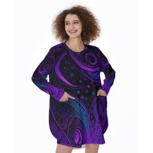 Woman wearing a purple patterned dress, smiling.