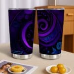 Purple patterned tumblers on wooden table.